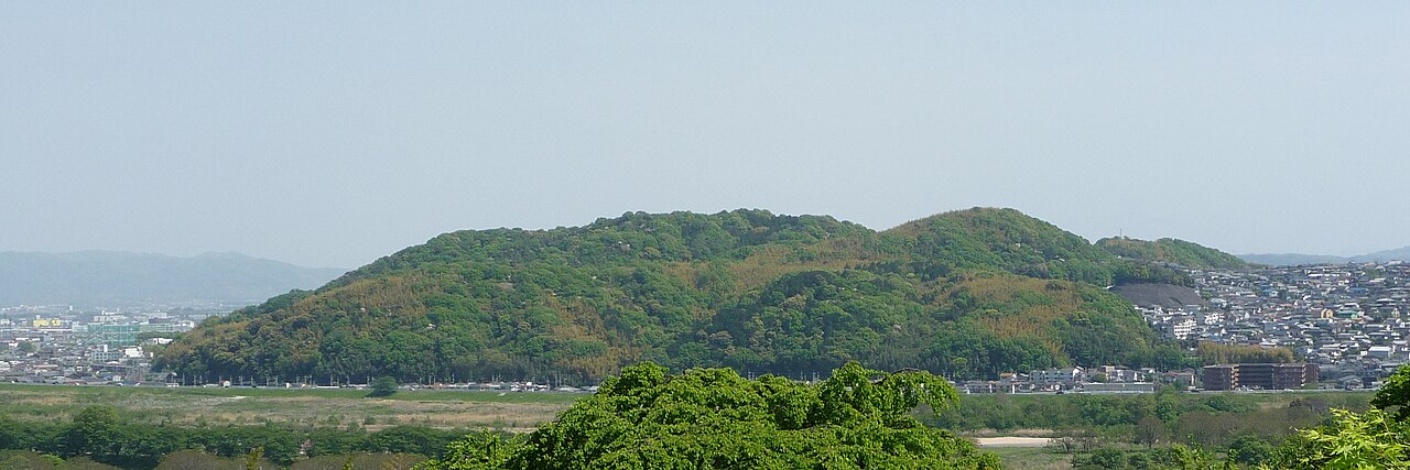 大山崎山荘美術館のテラスから望む男山。手前に緑地が広がり、山のふもとに住宅地が続いている