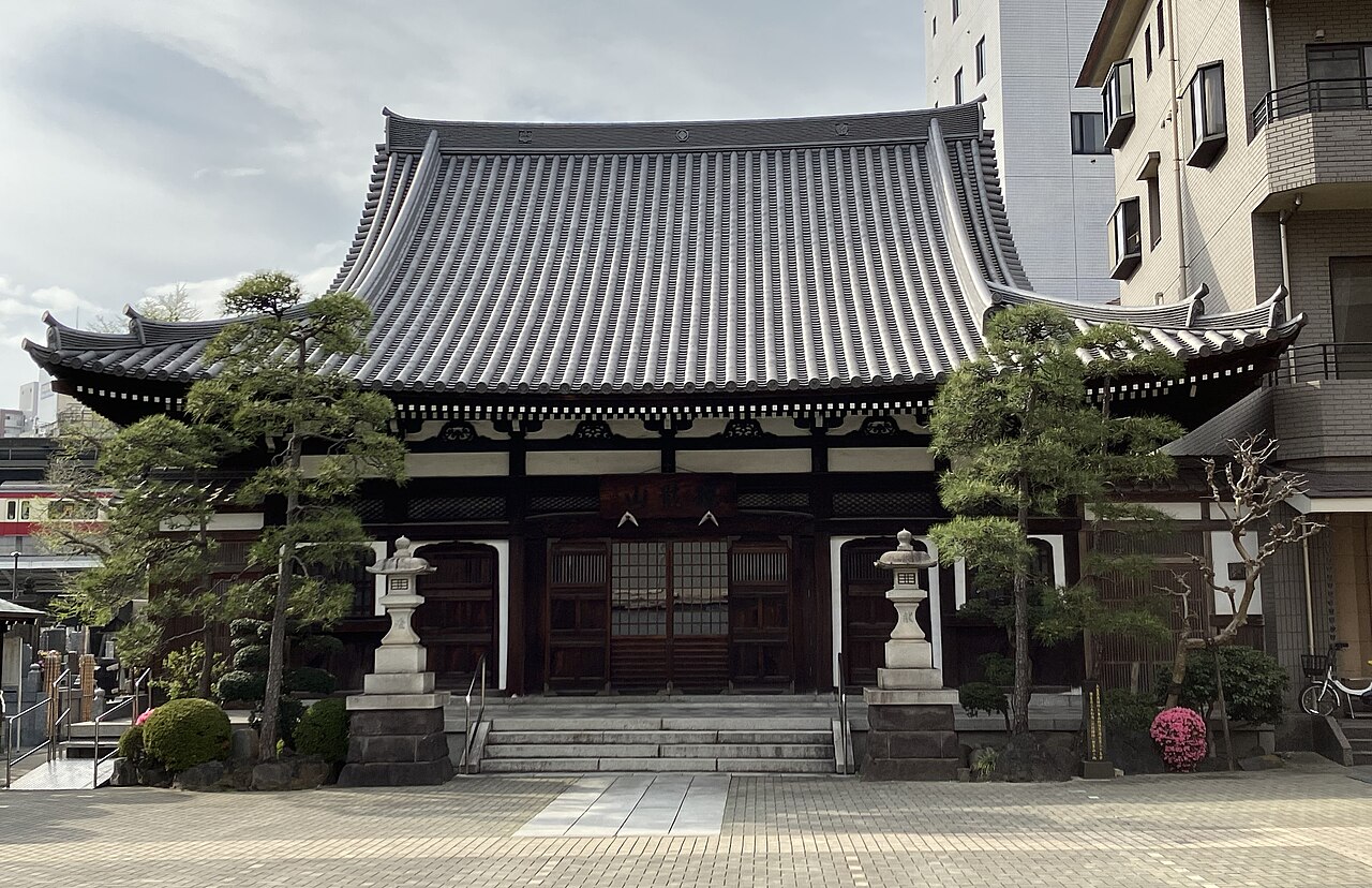 川崎区砂子の宗三寺の境内。石灯籠と階段の奥に瓦屋根の建物が見える