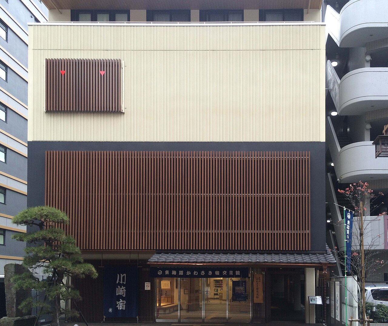 東海道かわさき宿交流館の外観。格子状の縦線のある建物