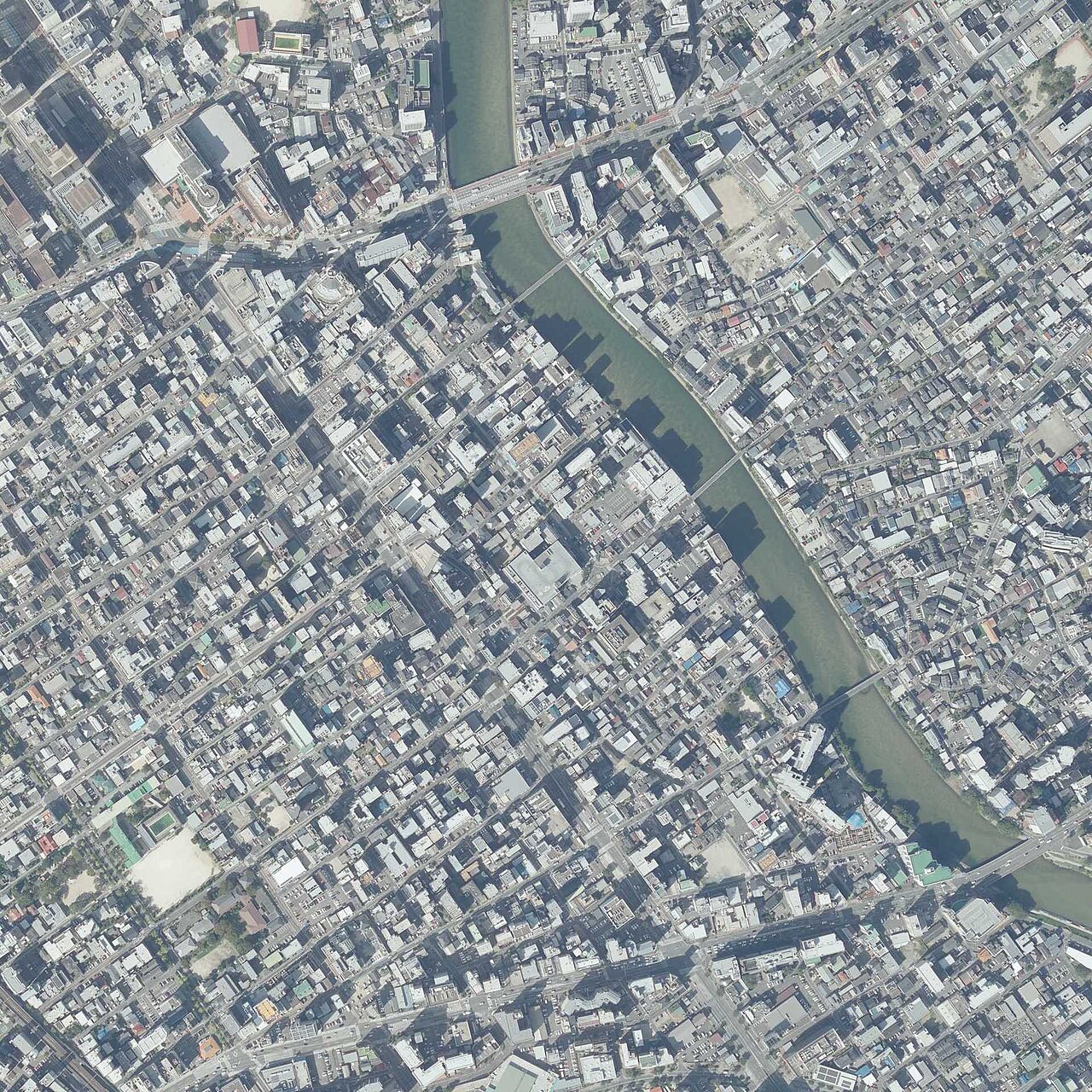 福岡市中央区清川一丁目から三丁目周辺を真上から写した航空写真。川沿いに小さな建物が密集している