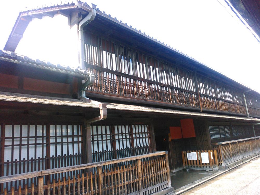 格子と欄干が連なる木造2階建ての角屋の外観