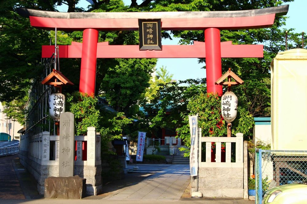 赤い鳥居と石の玉垣が並ぶ洲崎神社の入口