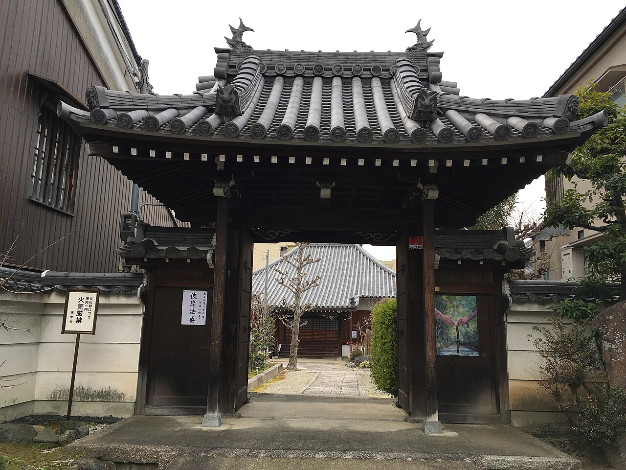 奈良市東木辻町にある称念寺の山門。瓦屋根の門の奥に本堂が見える