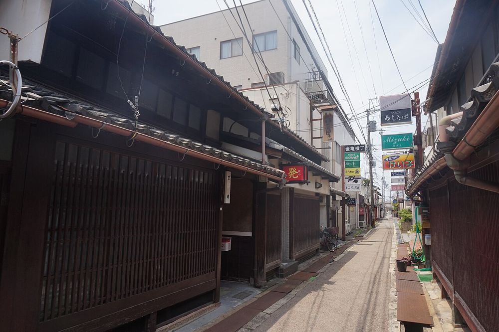 彦根市袋町(河原2丁目)の一角。黒い格子の木造の建物が通りに面して並ぶ