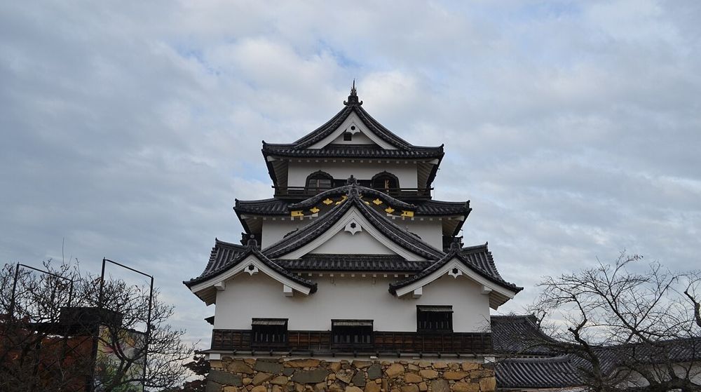 彦根城の天守。白壁と黒い屋根の三重の天守が、石垣の上に立つ